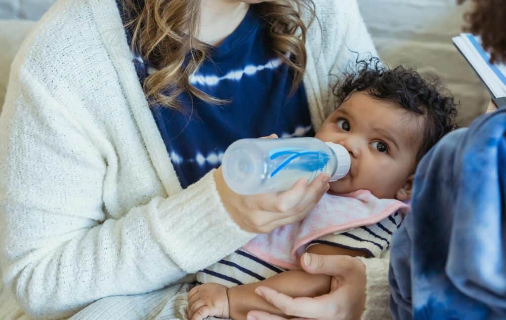 woman bottle feeding baby