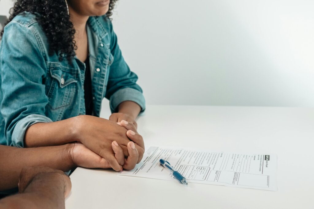 couple holding hands adoption document on table