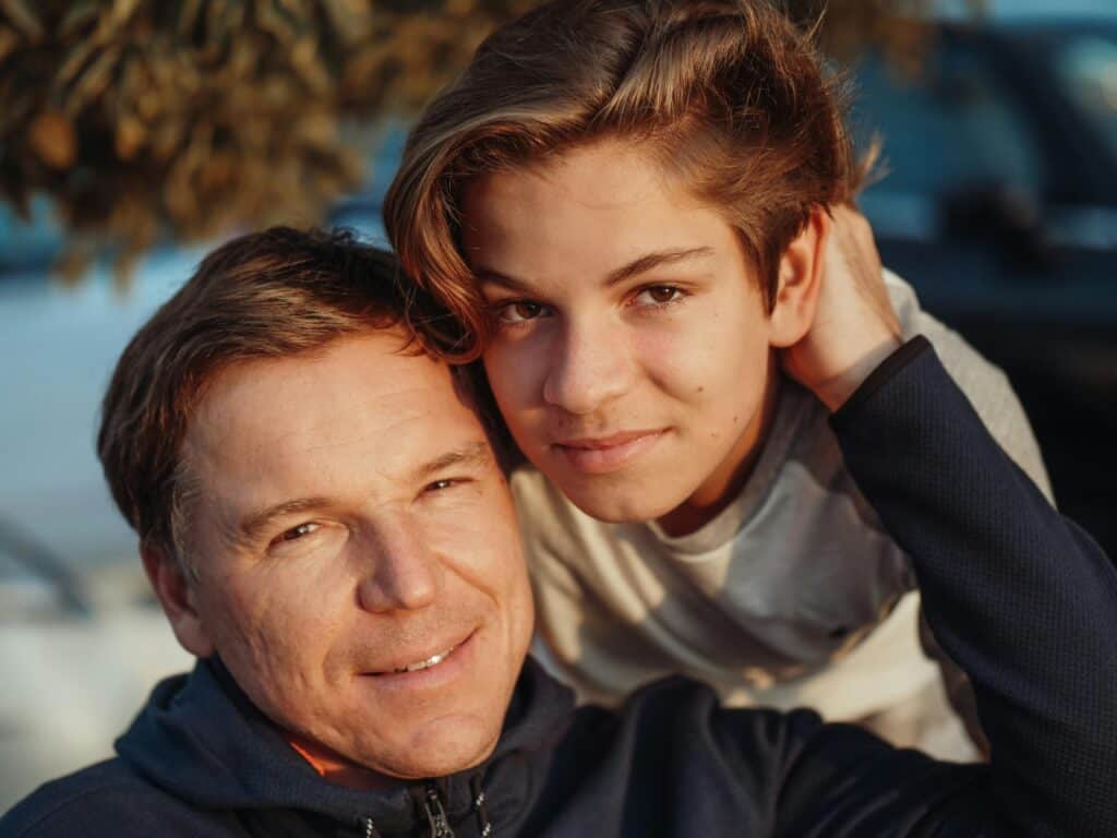 father and teen son smiling