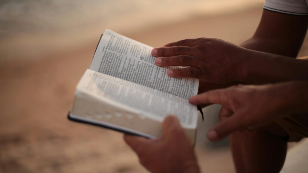 two sets of hands looking at Bible together