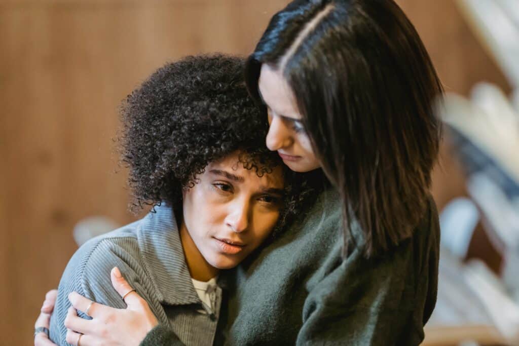 woman hugging sad female friend