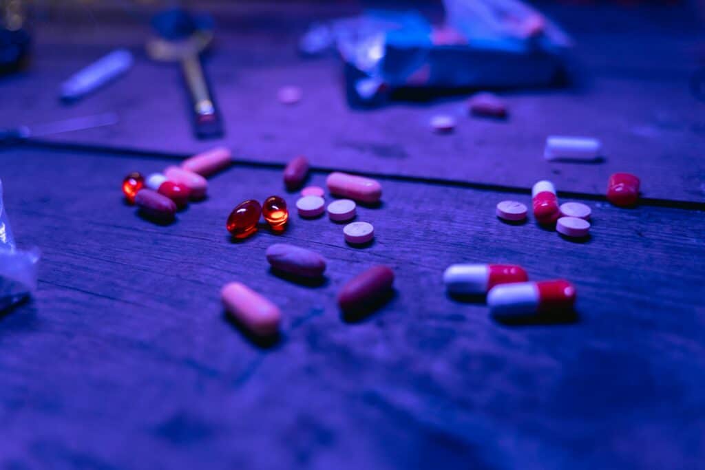 images of pills strewn around dark background