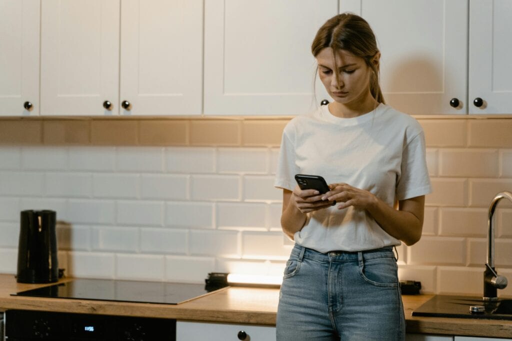 woman in kitchen unhappy looking at phone