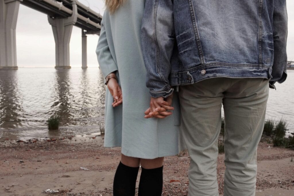couple holding hands behind backs