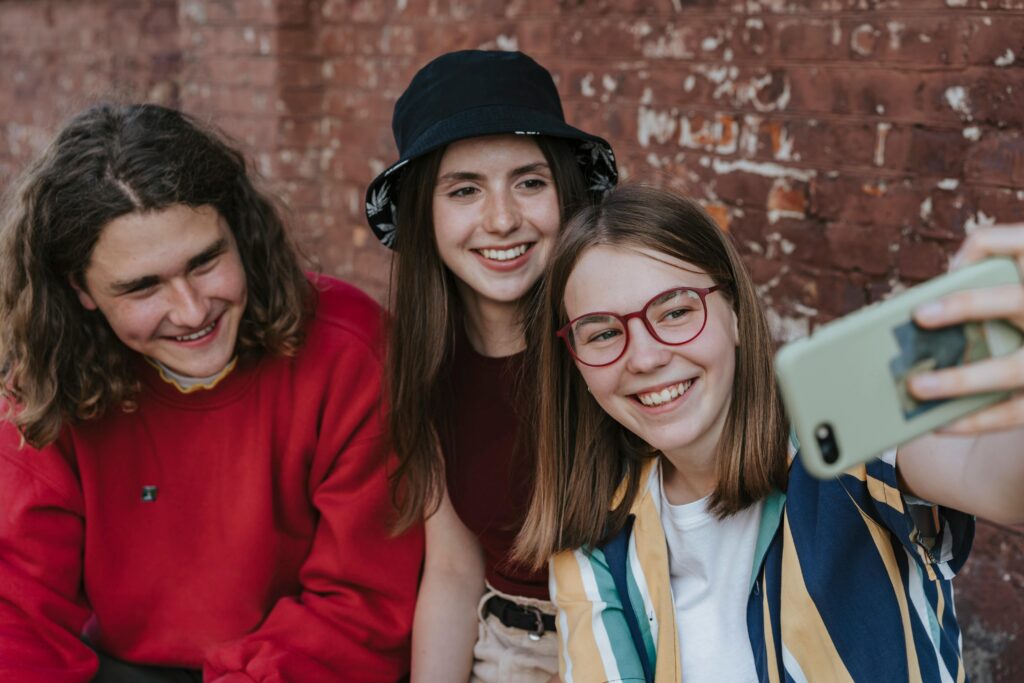 teen guy and two teen girls taking selfie