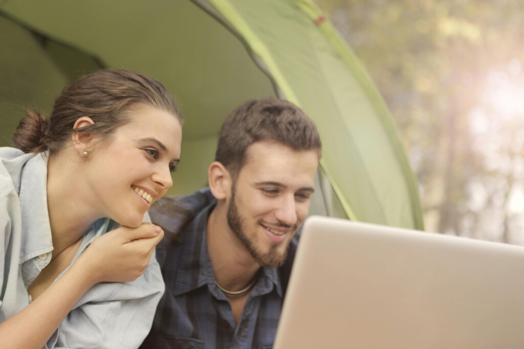 couple in tent looking at computer together