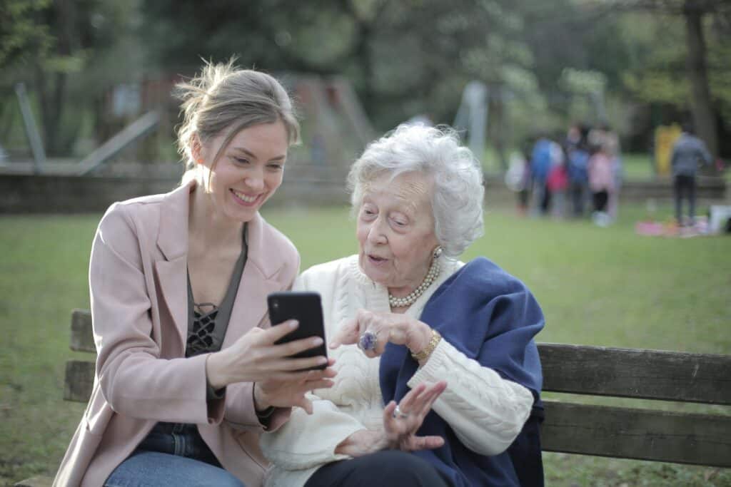 woman looking on phone with older woman grandmother