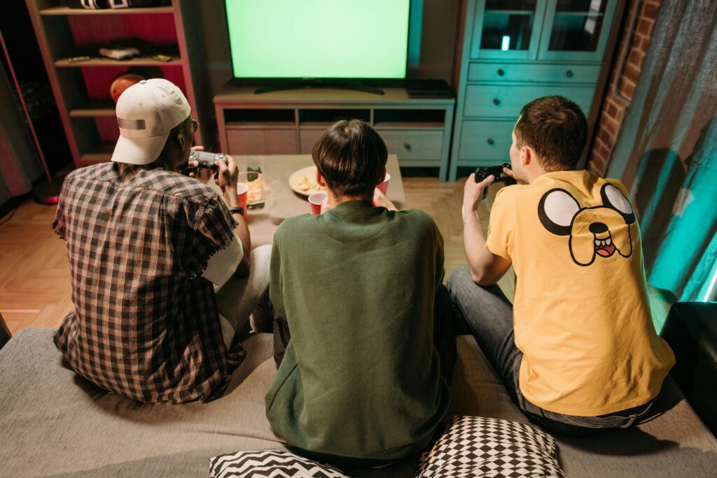 backs of three men playing video games