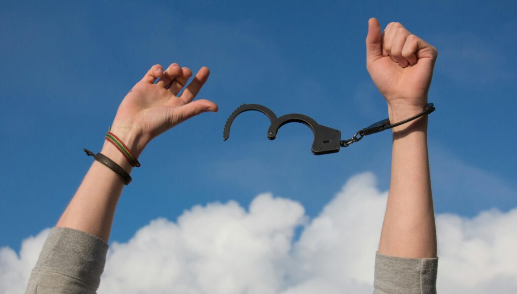 man's hands breaking out of handcuffs