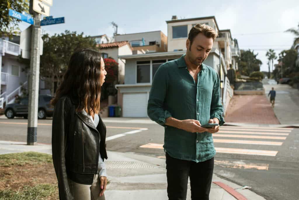 man and woman on sidewalk man on phone woman mad