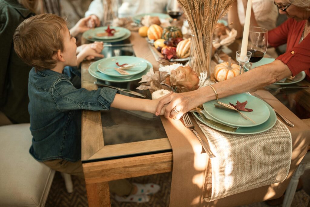 family praying meal holding hands child