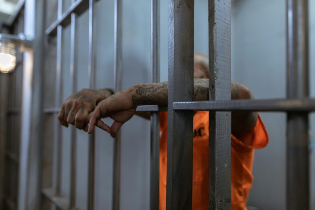 hands of prisoner reaching through bars