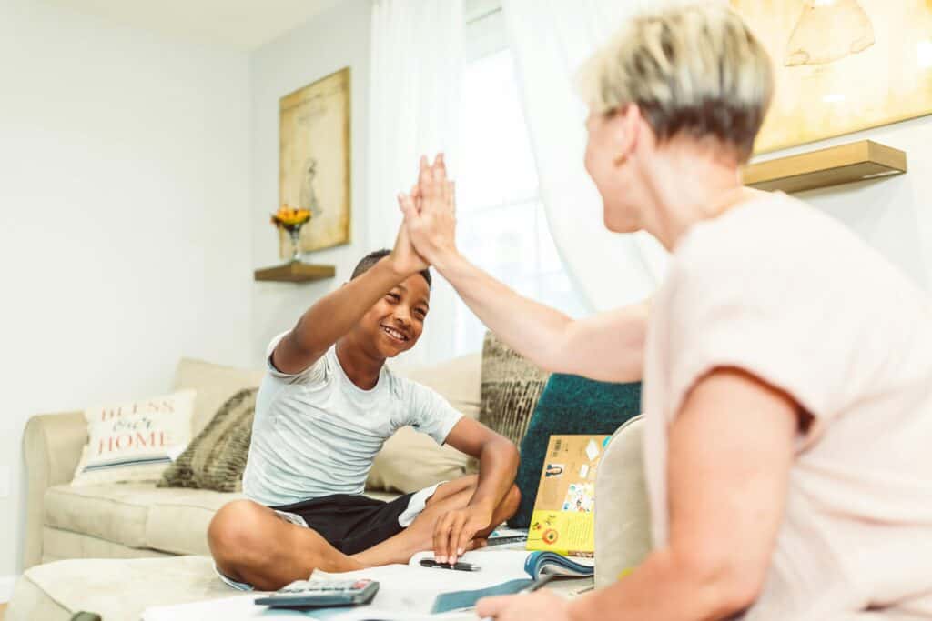 boy high fiving mom on bed