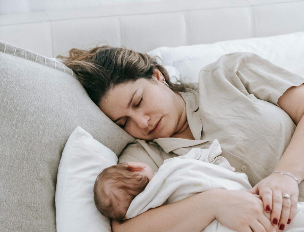 Woman sleeping holding baby
