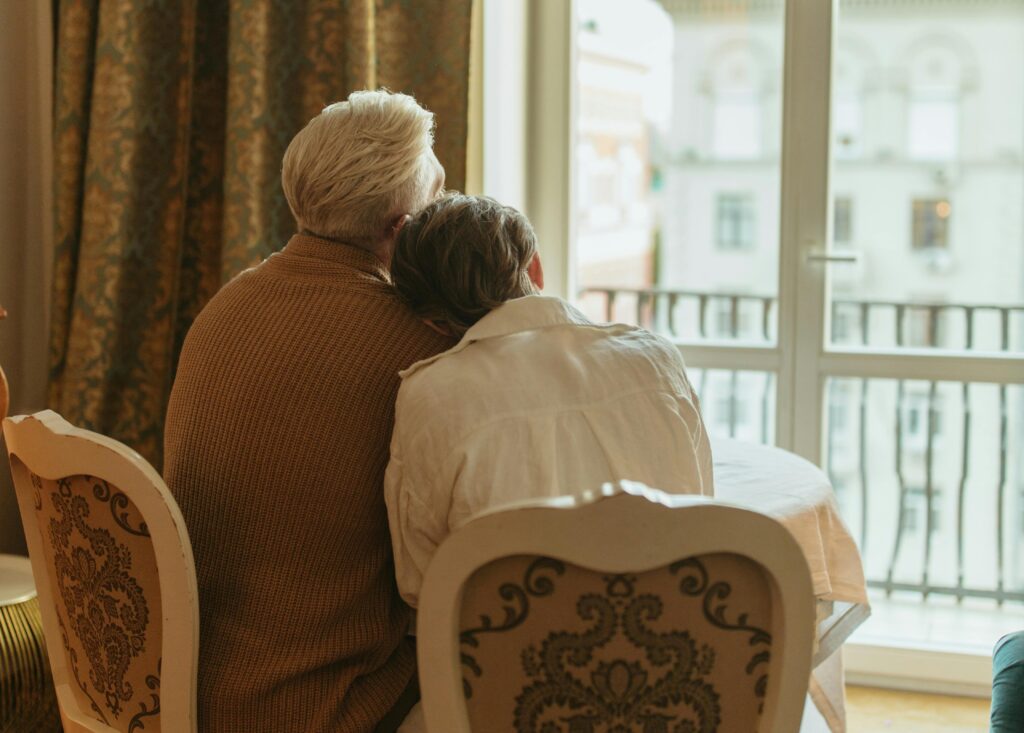 older couple looking out window