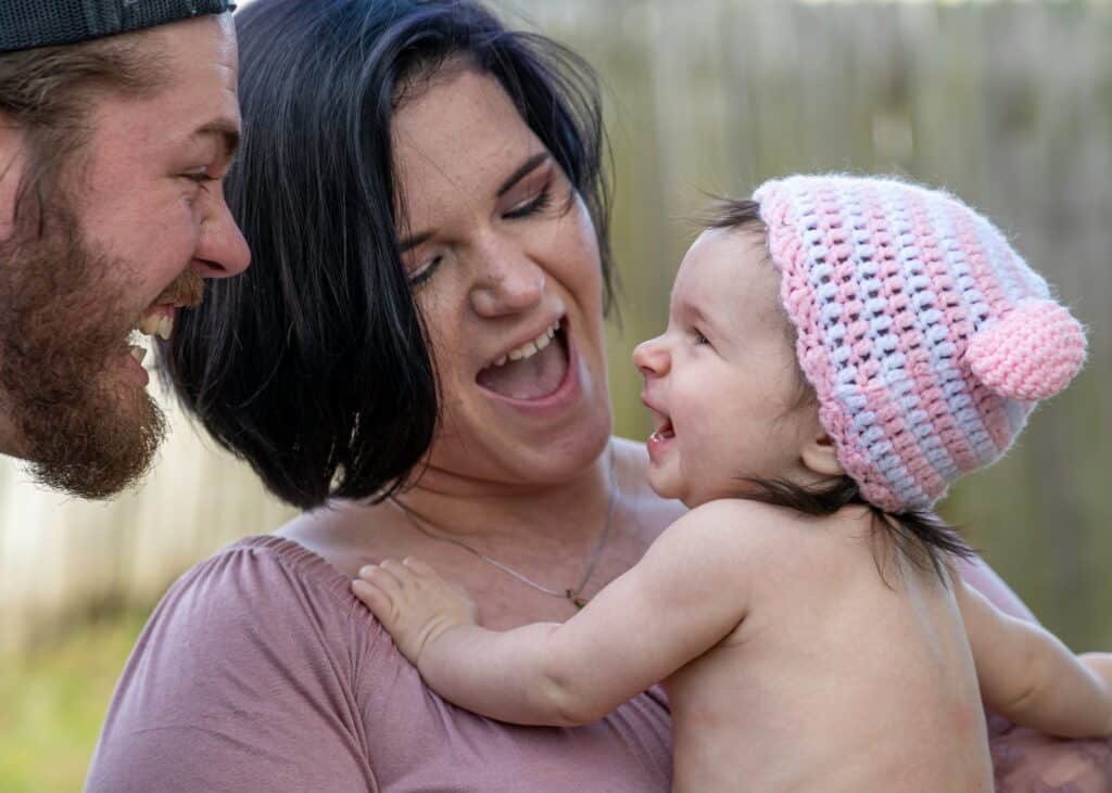 mom and dad smiling at baby