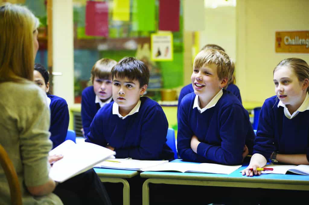 kids in uniform listening to teacher