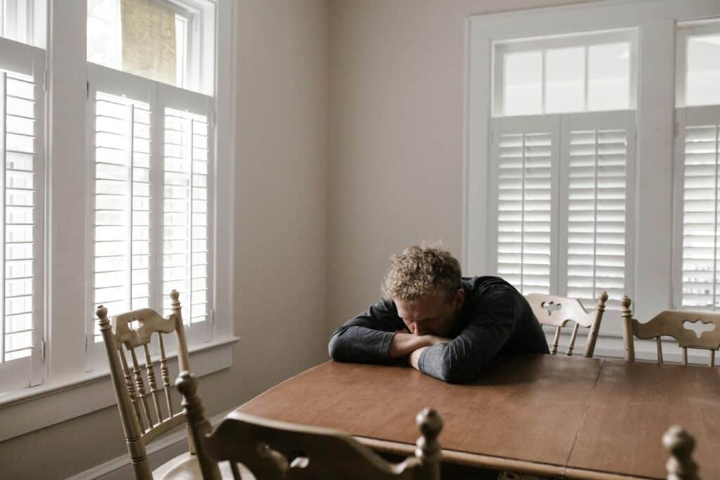 Man sitting at a table with his head down