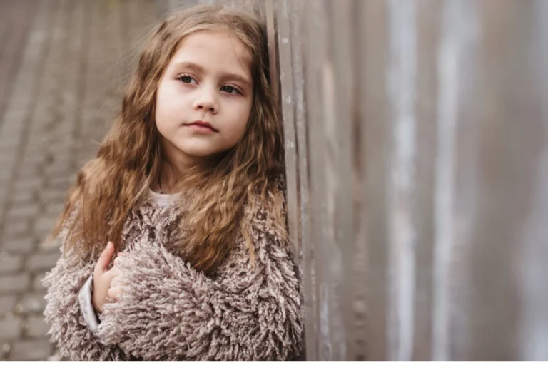 Flexible thinking is a valuable life skill for children. This little girl is leaning on a wall thinking deeply