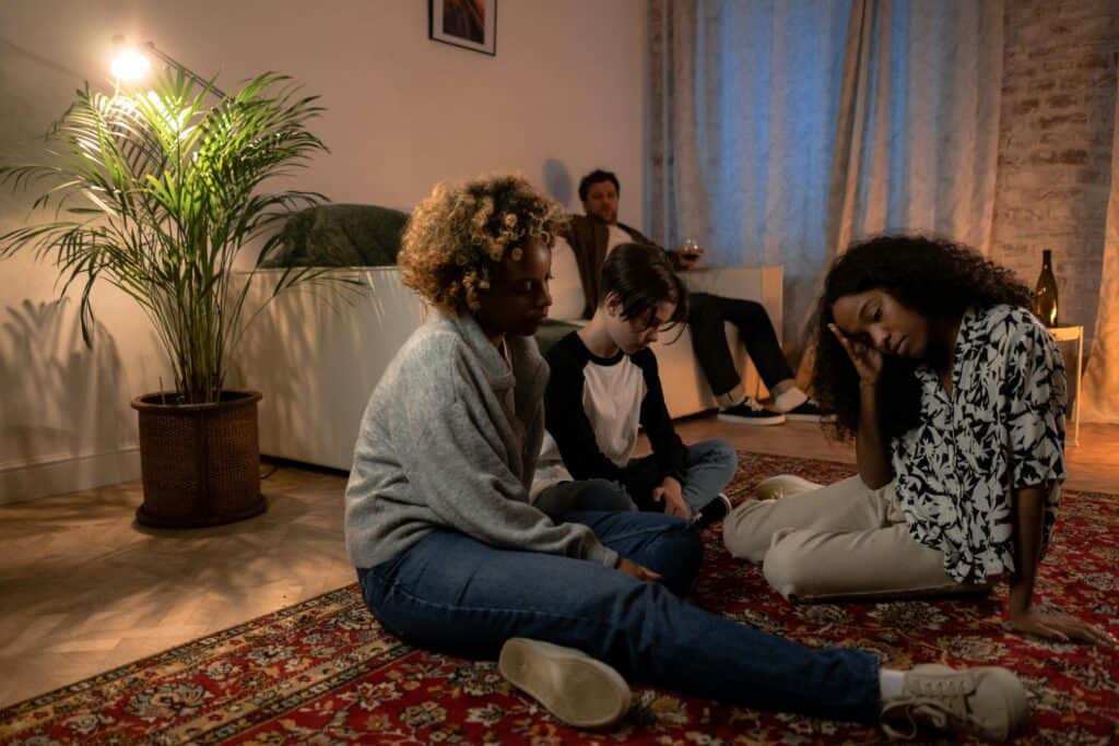 family sitting on floor sad, dad on couch