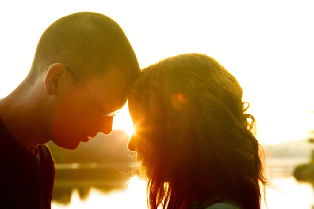 Couple sharing a quiet moment, symbolizing spiritual connection in marriage at sunset.
