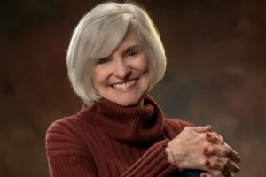 Nancy Rue smiling wearing a brown turtleneck sweater