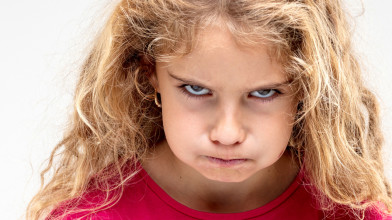 Portrait of preteen girl making an angry face
