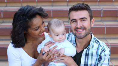 A smiling couple holding their baby, representing the concept of how to align your dreams as a couple for a happy and harmonious family life.