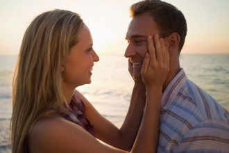 A couple stands by the ocean, lovingly gazing into each other’s eyes, as the wife has learned how to communicate better with her husband.