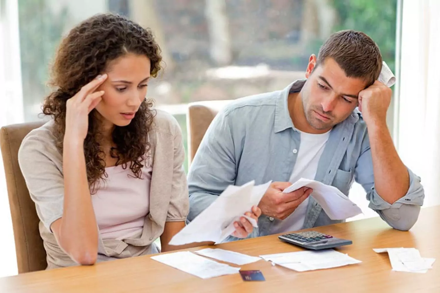 A couple looks over financial documents together, emphasizing the communication and collaboration needed for a financially healthy marriage