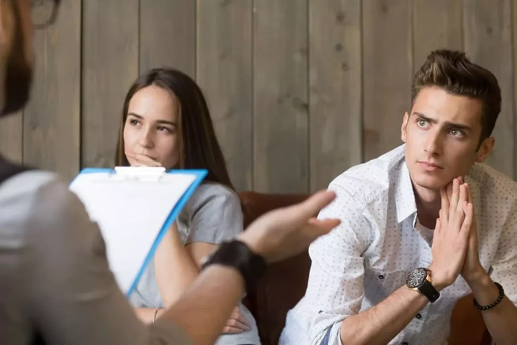 Counselor confronting husband in office as wife looks on