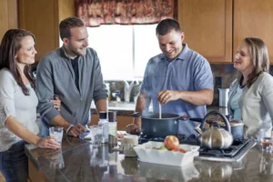 Two young couples hanging out in a kitchen, enjoying each other's company