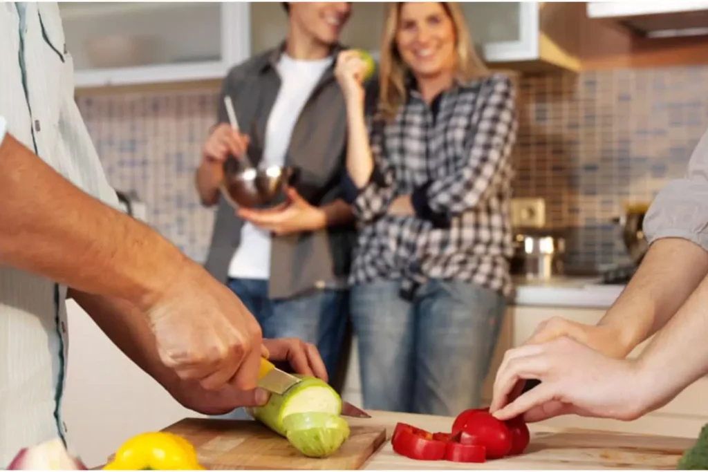 A married couple works together in the kitchen, preparing food as part of their shared act of serving others.