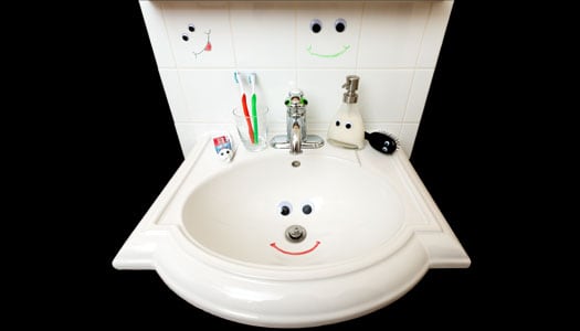 A bathroom sink decorated with happy faces