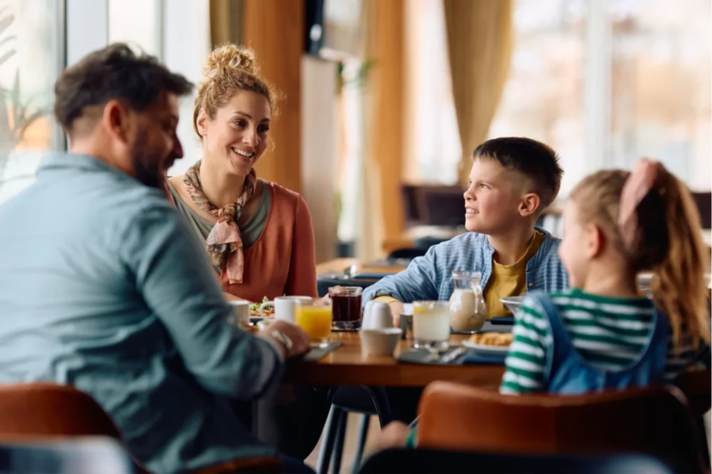 family sitting around the breakfast table. Mom, dad, twelve year old boy and seven year old little girl