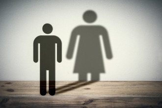 Generic male image in foreground, casting shadow of generic female image in back, suggesting transgenderism