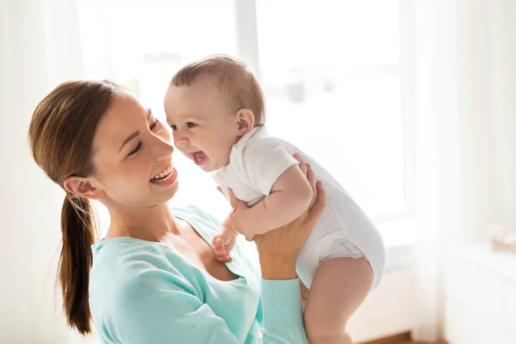 Happy single mom playing with her laughing baby