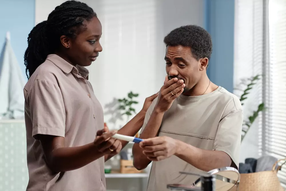 Dad looking shocked as wife shows him a positive pregnancy test