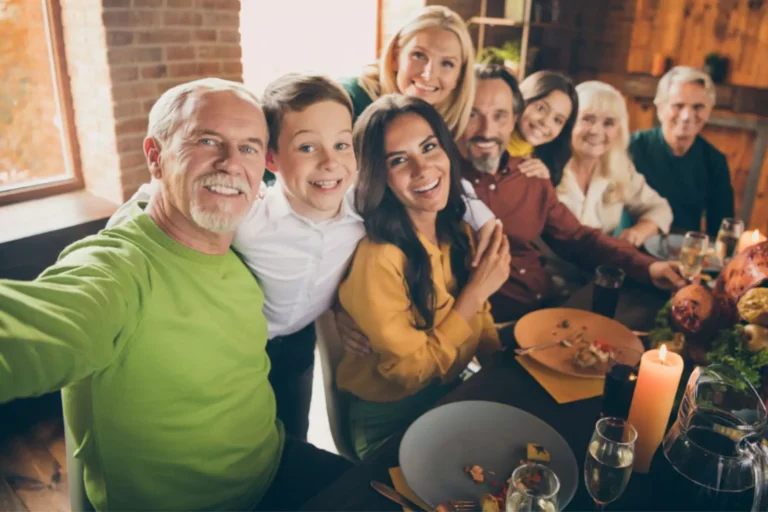 Family lining up around the table for a Thanksgiving selfie.