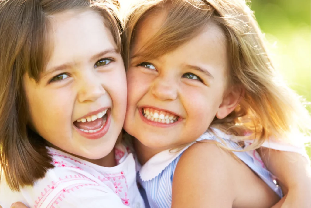 Two smiling siblings hugging outdoors, illustrating how to repent, forgive, and restore relationships through love and understanding.