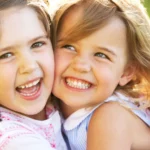 Two smiling siblings hugging outdoors, illustrating how to repent, forgive, and restore relationships through love and understanding.