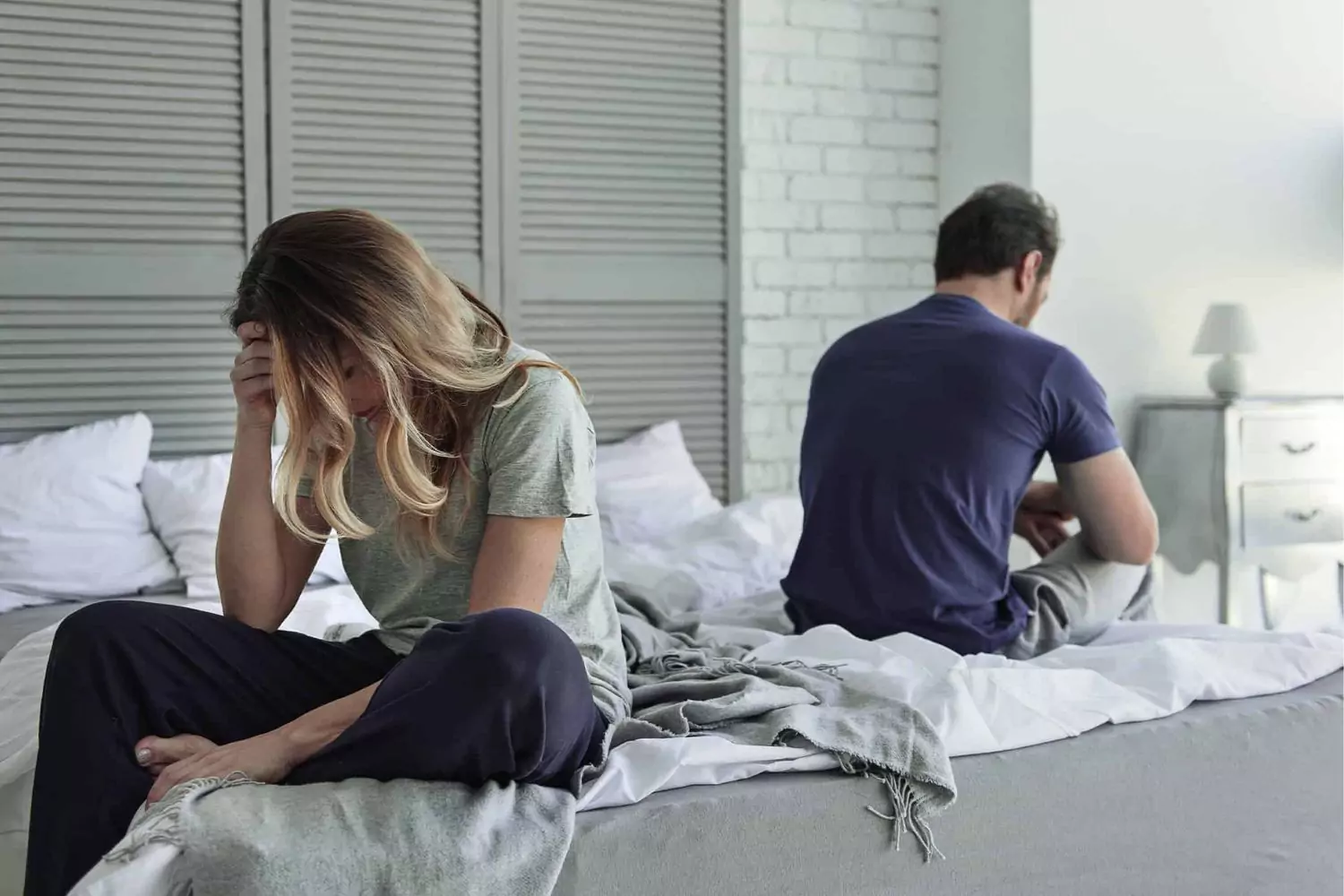 Unhappy-married-couple-sitting-on-bed-not-facing-each-other
