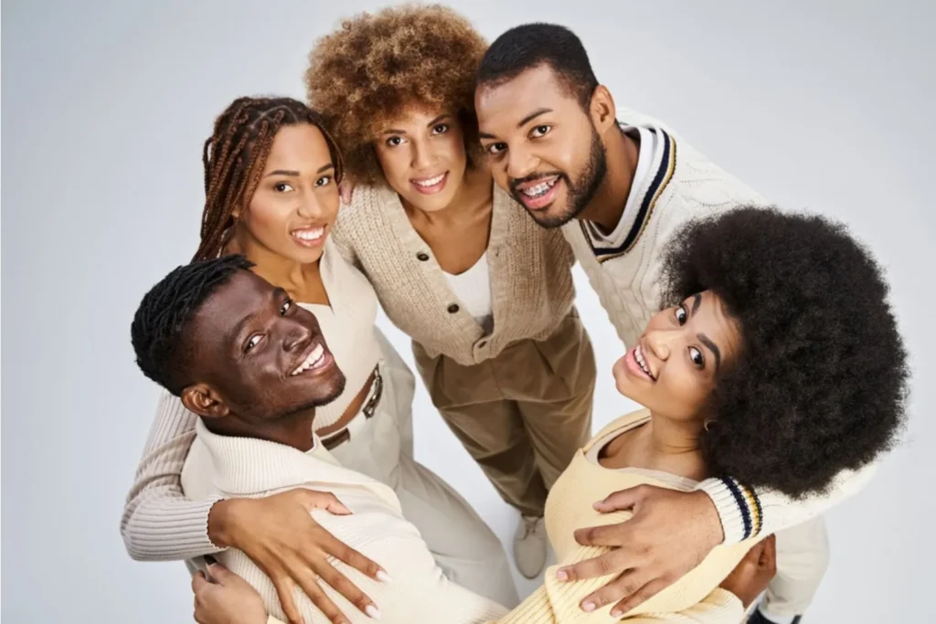 Five young adults in a circle looking up and celebrating happy Juneteenth
