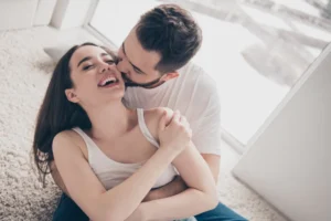 A couple embraces intimately, their foreheads touching as they prepare to kiss, symbolizing vulnerability and connection in conversations about a partner’s sexual past.