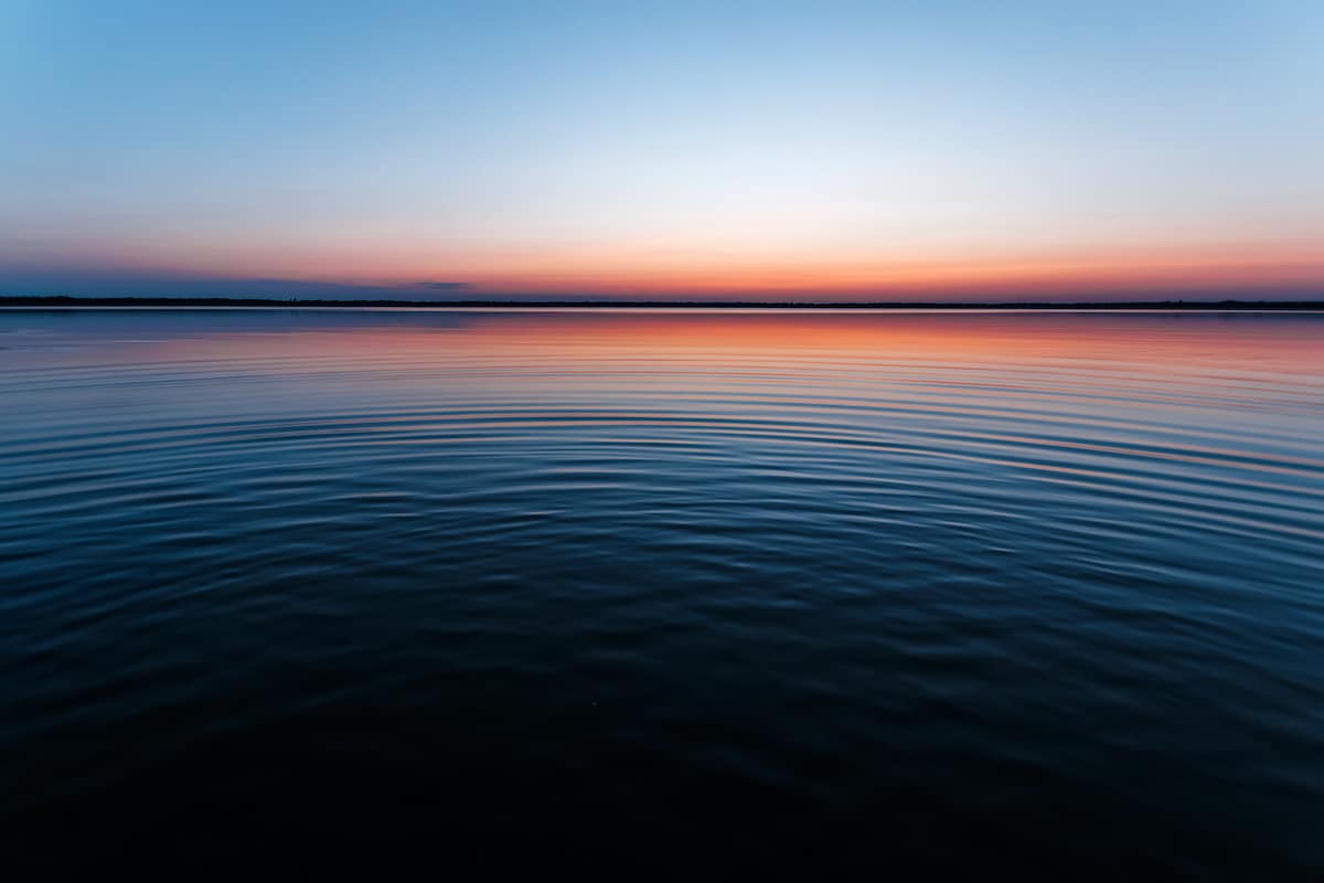 Circles on the water against a beautiful, pink sunset. The magic time of day.
