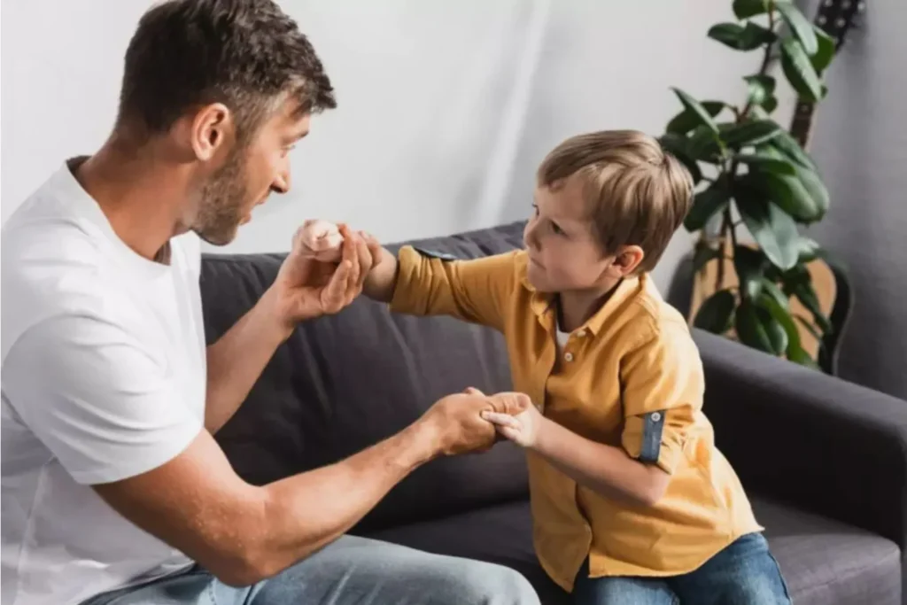 Father talking to his son on the couch, holding hands, and talking about being thankful