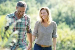 A woman and man walk hand-in-hand through a green garden. What is the difference between loving and cherishing your spouse, and what does cherishing your spouse mean?