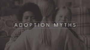 A faded image of a mother hugging two racially diverse children while they are both smiling. There is a white caption with thin white lines above and below it that say: " Adoption Myths"