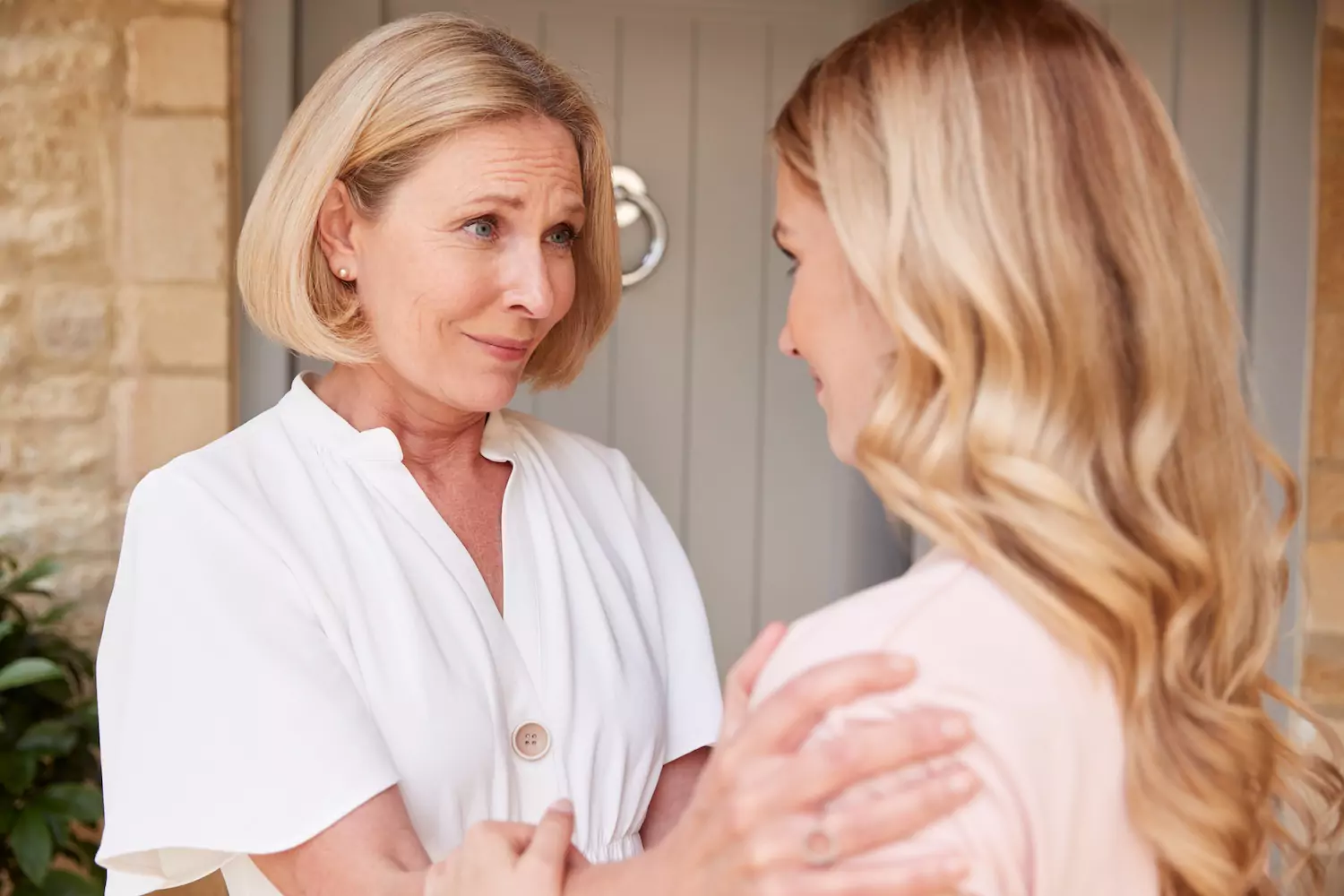 A mature woman says goodbye to her adult daughter at the door of her house. Here is some information on empty nest syndrome and our relationship with God.