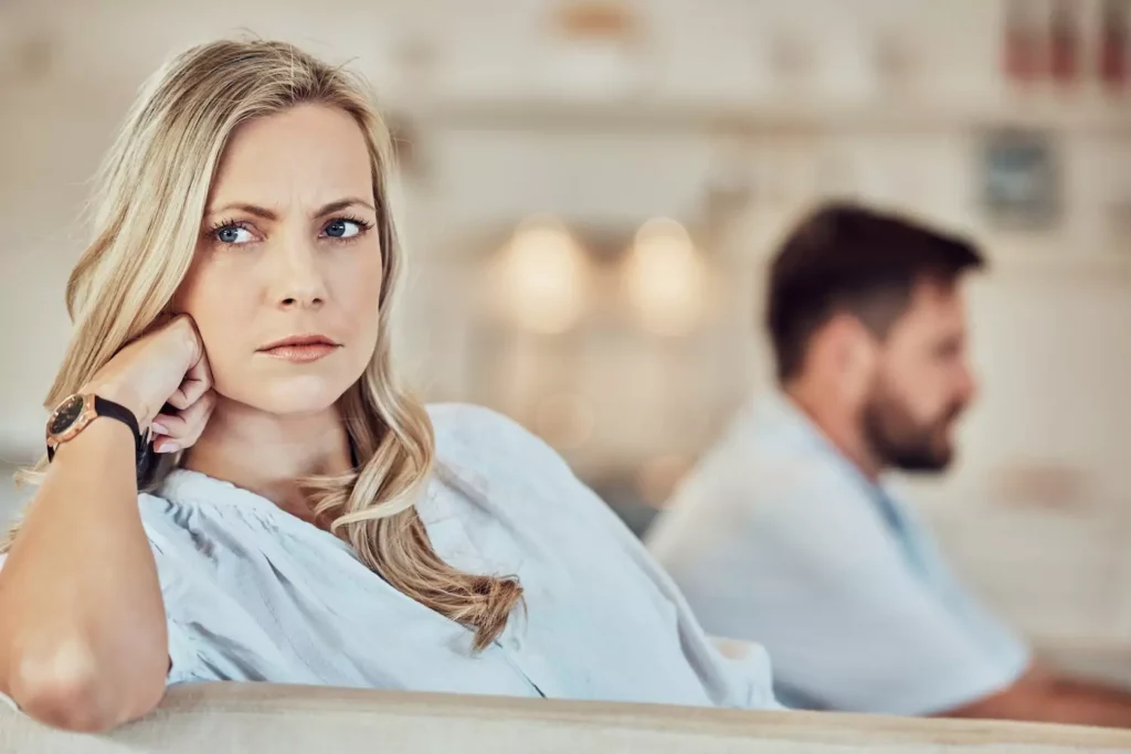 An angry woman sits at the end of a couch, clearly angry with the bearded man sitting on the other end of the couch. There is plenty of motivation to learn how to deal with anger in your marriage effectively. Here are a few scenarios to consider.